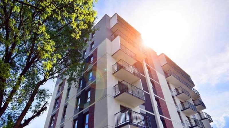 Modern residential apartment building exterior beside mature trees