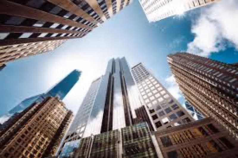 Modern glass office towers viewed looking upward against a blue sky